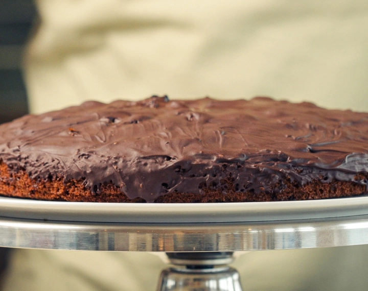 Space cake casero con cannabis terminado, cubierto con chocolate negro derretido, servido como un postre comestible clásico