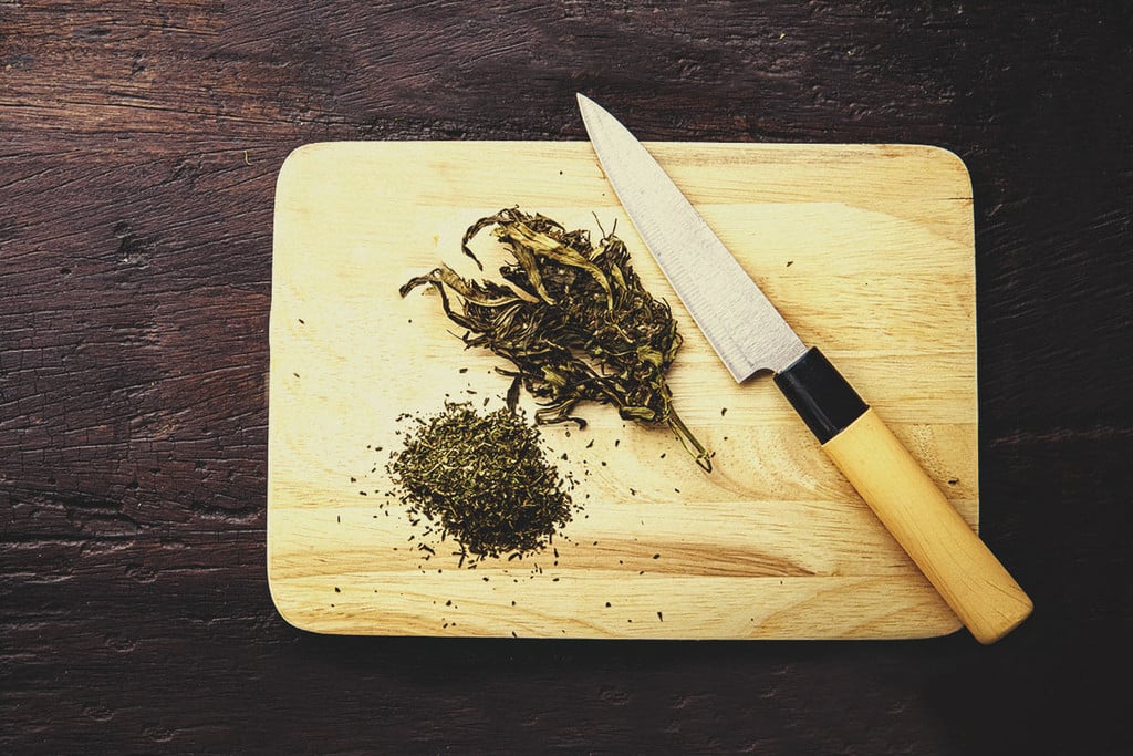 Grinder para marihuana con hoja de cannabis grabada.